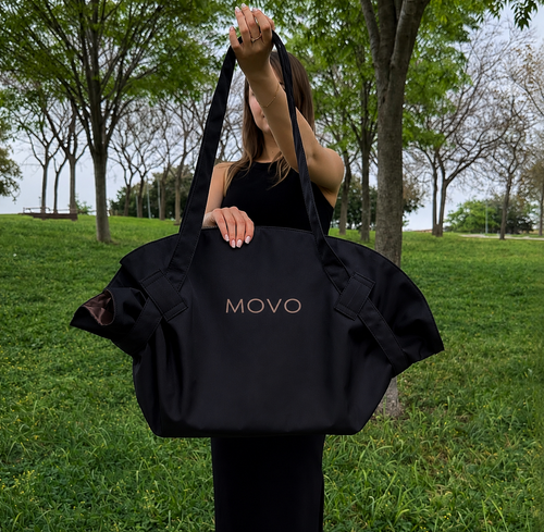 Woman carrying the black Movo Bag over her shoulder in the park